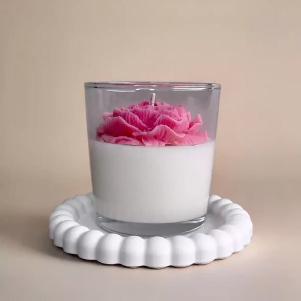 Handmade soy wax candle with wax flower in a glass jar