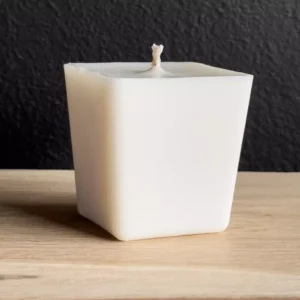 Square Scented candle refill next to a matching plaster container, with several scent options in the background.