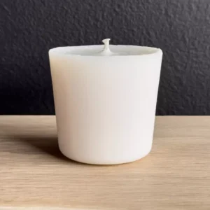 Round Scented candle refill and plaster container with different scents in the background.